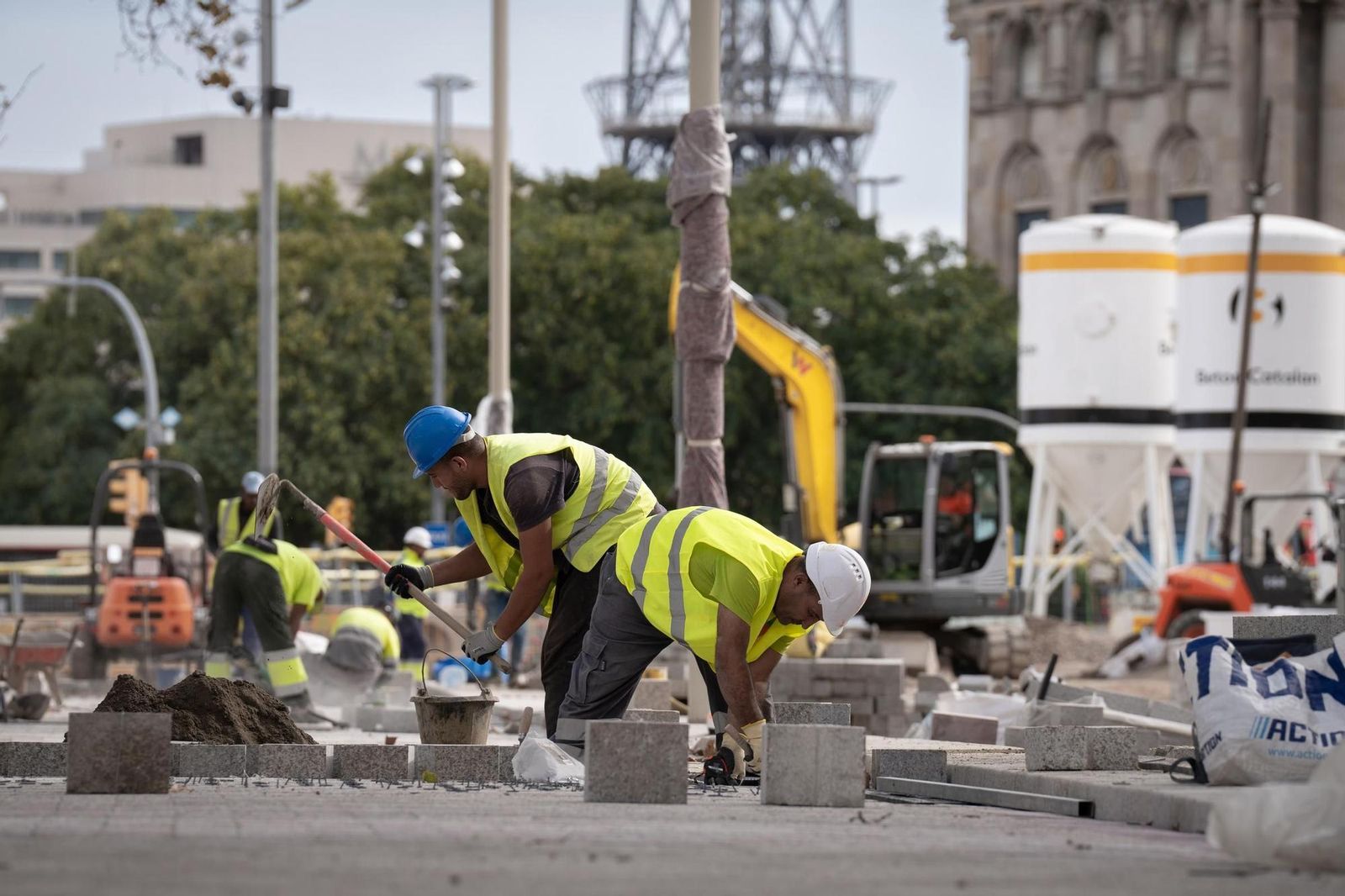 Treballadors col·locant paviment en una obra urbana