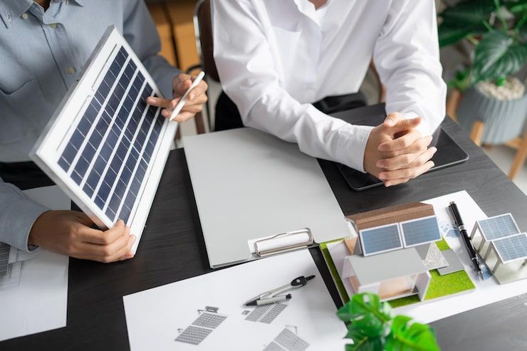 Enginyers dissenyant una instal·lació amb un mòdul solar a la taula